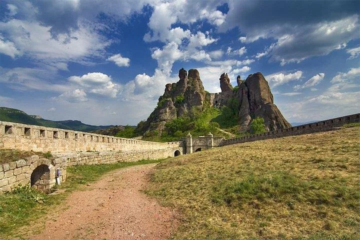 Belogradchik Fortress and dramatic rocks under a blue sky with white clouds.