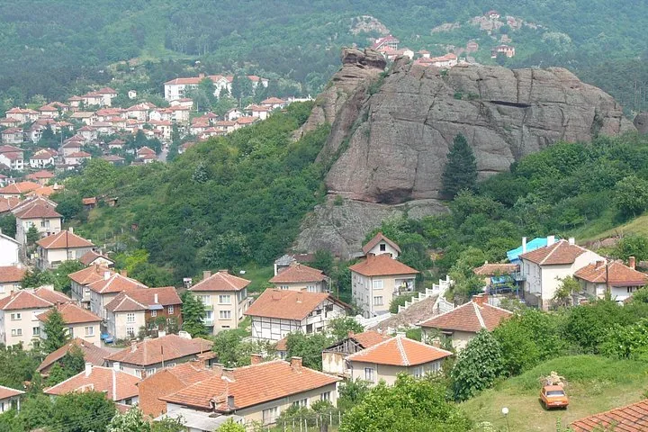 Vista de un pueblo enclavado bajo grandes e imponentes formaciones rocosas.