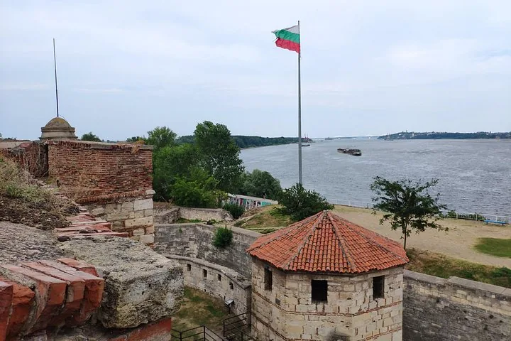 View of a river from a fortress with a flag flying high.
