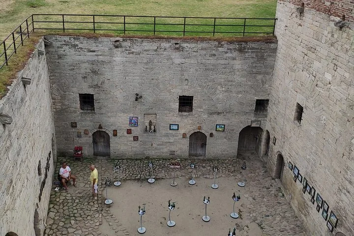 Courtyard of a historic building with stone walls and an art exhibition.